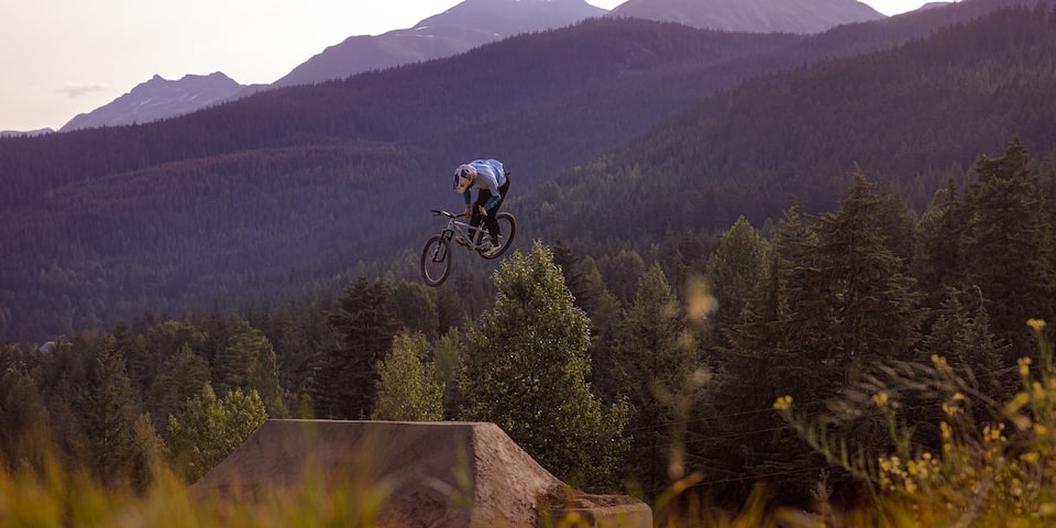 A person Mountain Biking on a Forest Environment at a Red Bull event.