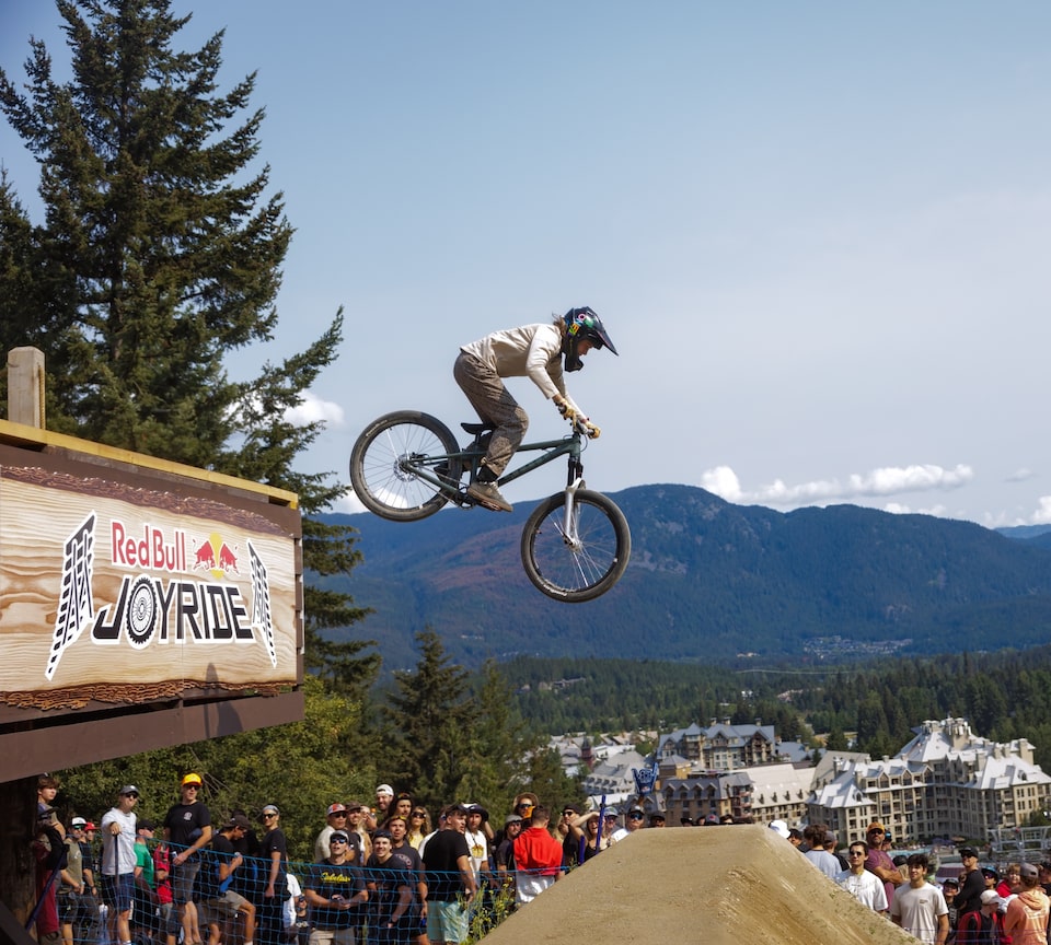 A biker performing a stunt to a crowd at a Red Bull Joyride event.