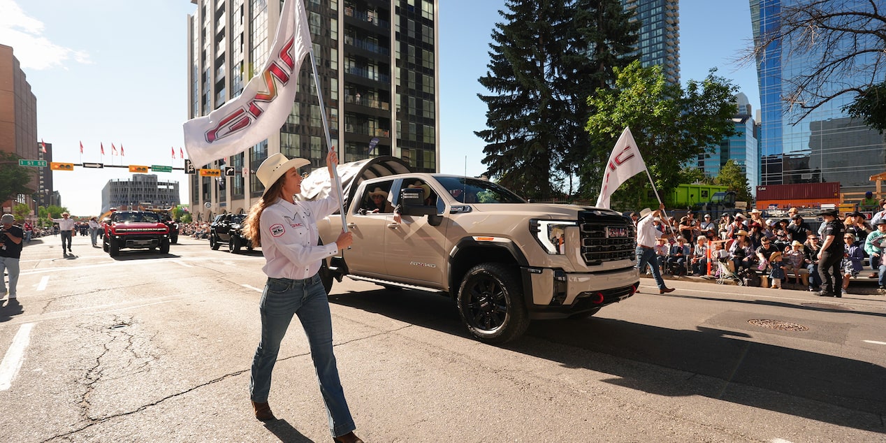 Woman holding GMC flag walking in the Stampede parade.