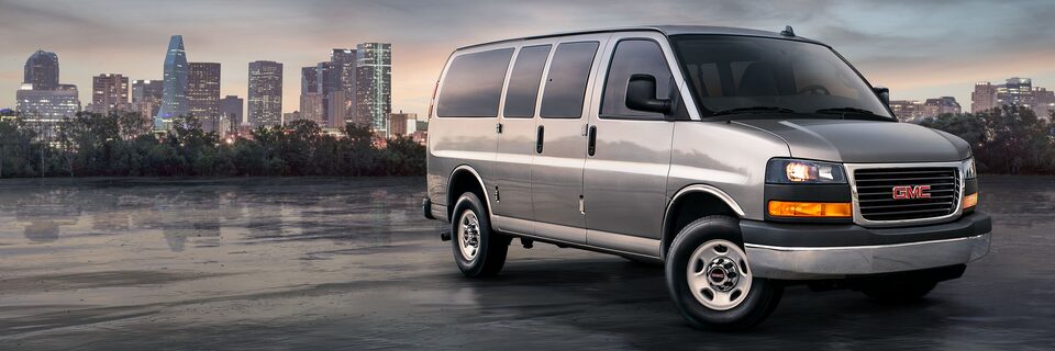 2023 GMC Savana Passenger with a city sky line.