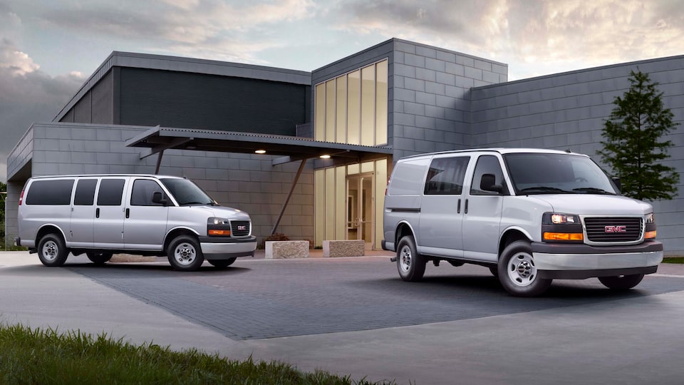 Two Savana Cargo vans parked outside a modern home.