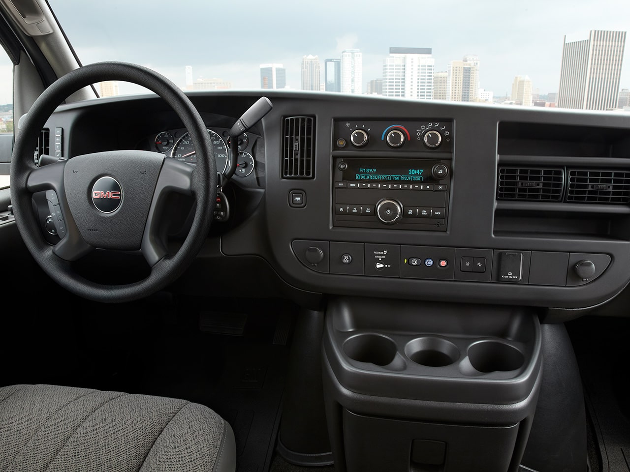 Wide Interior View of the Steering Wheel and Dashboard inside a 2026 GMC Savana Cargo Van.