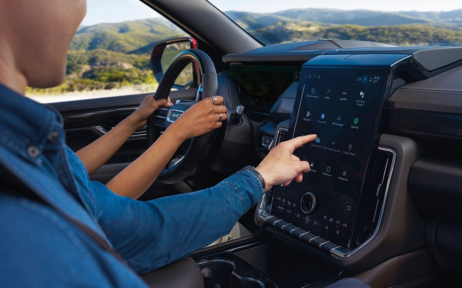 Une personne utilise des applications intégrées à l’aide de l’écran du système d’infodivertissement d’un véhicule GM abonné à OnStar.