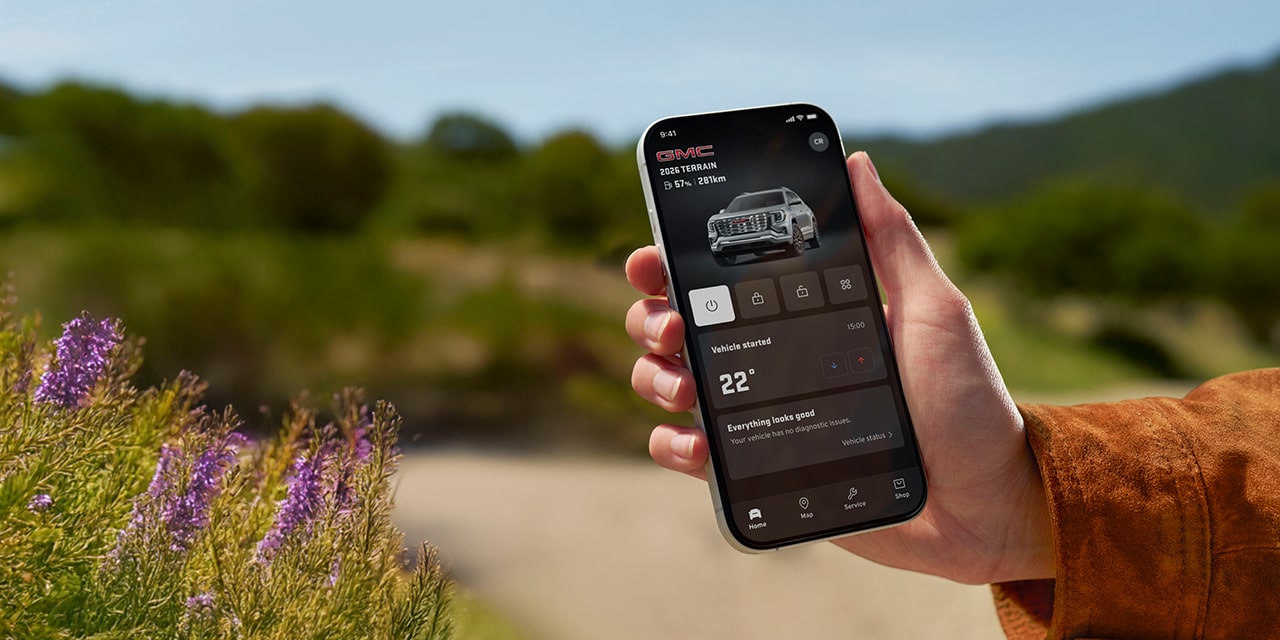 A Person's Hand Holding a Smartphone Displaying vehicle information on the myGMC Mobile App.