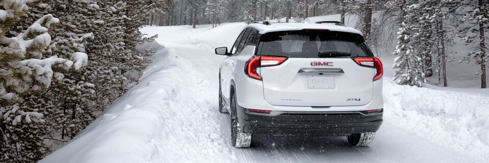 Vue arrière du GMC Terrain AT4 2022 sur une route enneigée.