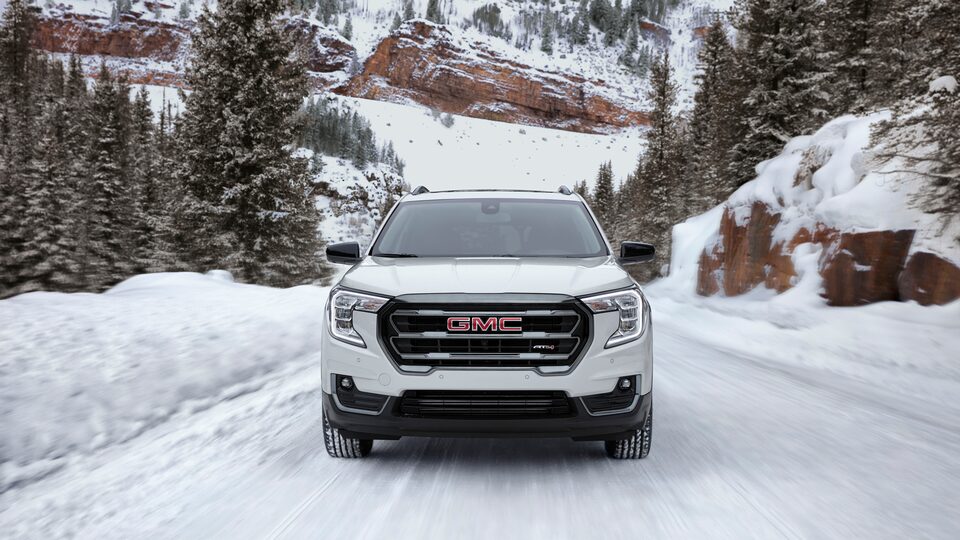 Vue avant du GMC Terrain AT4 2022 sur une route enneigée.