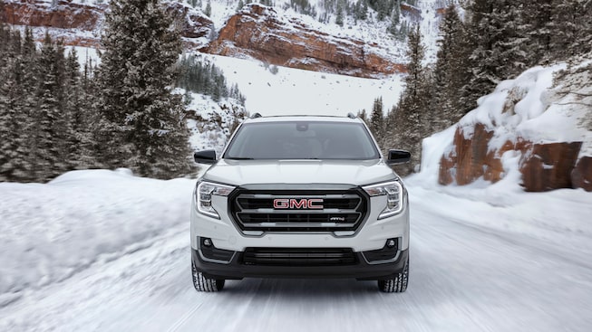 Front view of the 2023 Terrain AT4 driving on a snowy road.