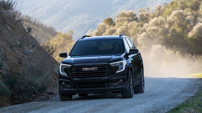2023 Terrain SLE/SLT Elevation Trim driving on a dusty road.