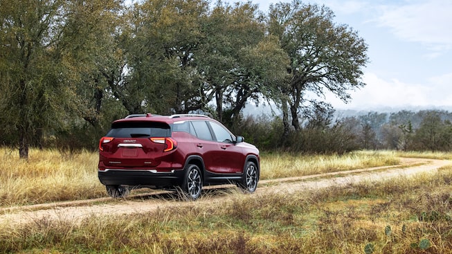 Back view of the 2023 Terrain SLE/SLT driving off-road.