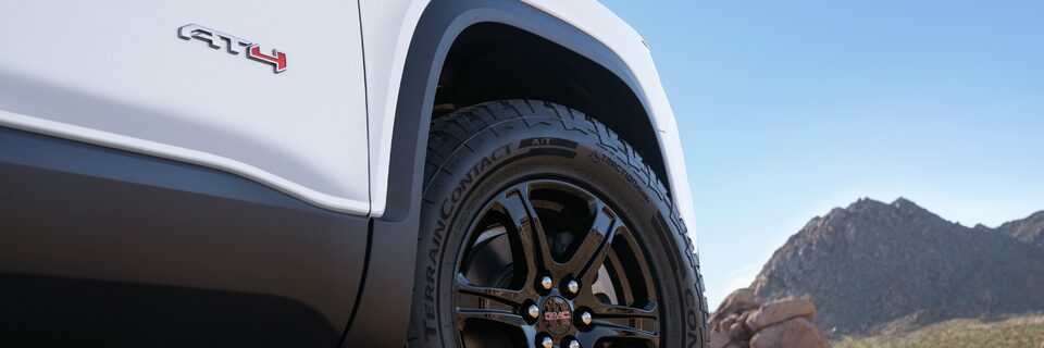 Vue rapprochée d’une roue en chrome noir du GMC Sierra AT4 2023.