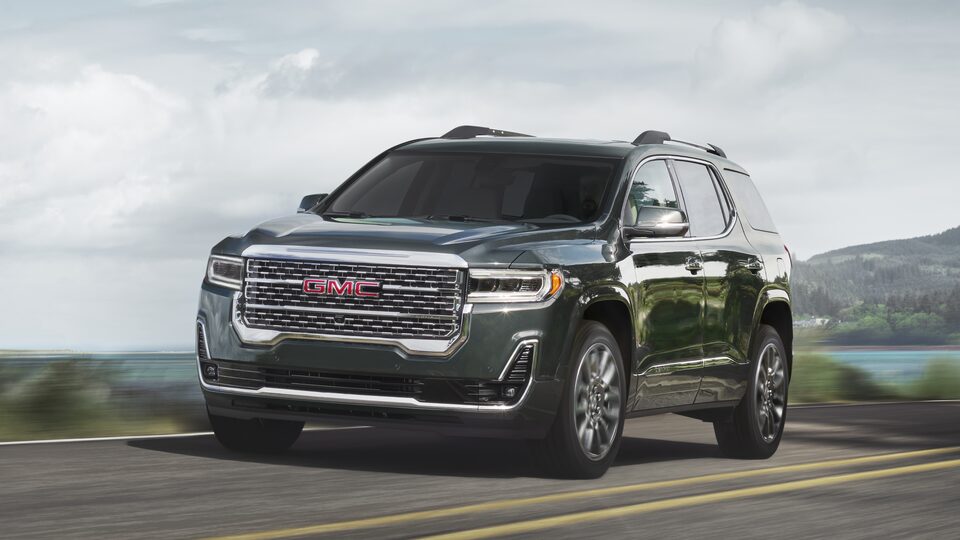 2023 Acadia Denali driving on the road.