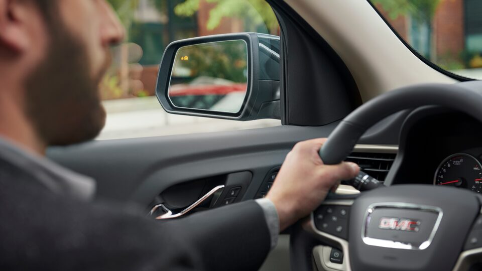 Man sits behind the wheel of a 2023 GMC Acadia.