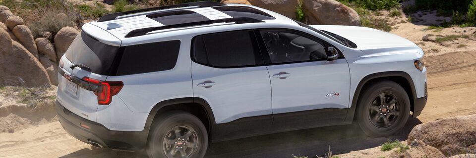 Vue latérale d’un GMC Acadia AT4 2023 en conduite hors route.