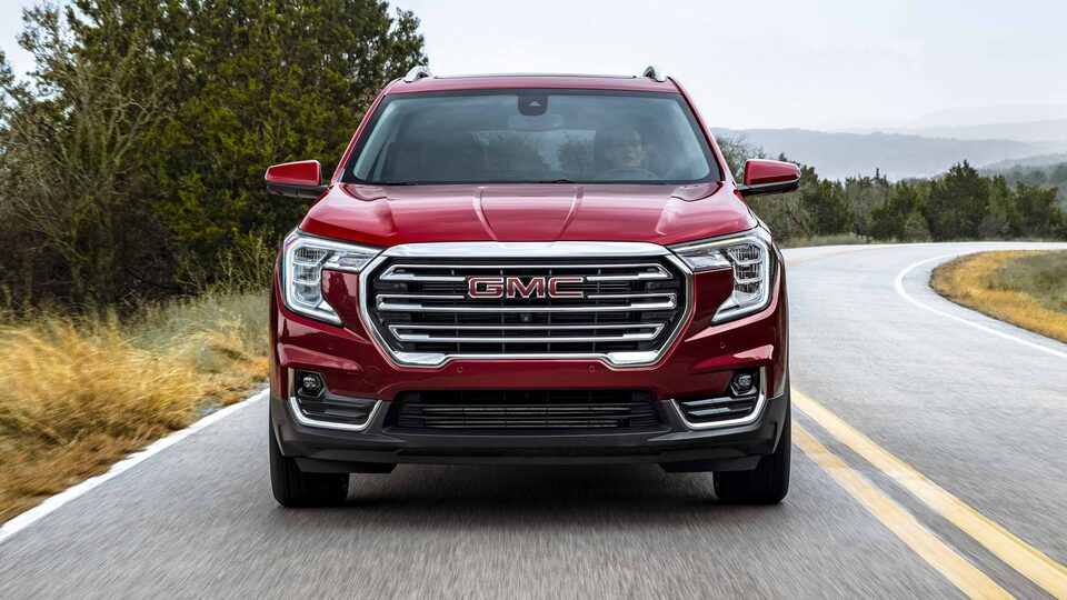 Front view of the 2023 Terrain SLE/SLT driving on the road.