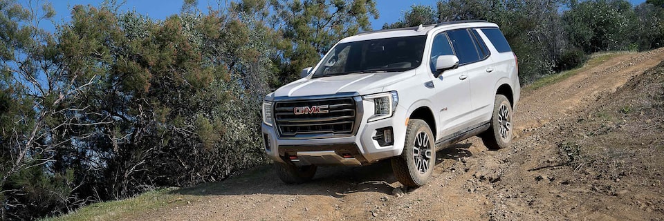 Front side view of the 2023 GMC Yukon AT4 driving downhill.