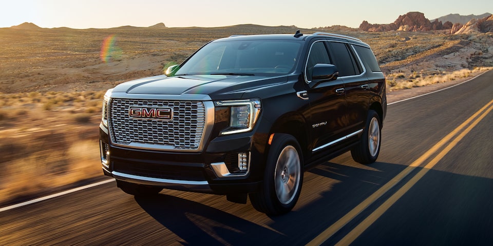 Front side profile of the 2024 Yukon driving outdoors