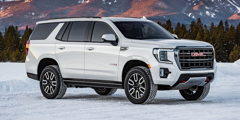 Side view of the 2024 GMC Yukon AT4 parked in a snowy environment.