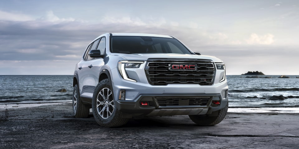 Front view of the 2025 GMC Acadia AT4 parked near a beach.