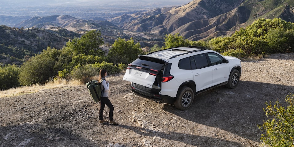 A person opening the trunk of the 2025 GMC Acadia AT4.
