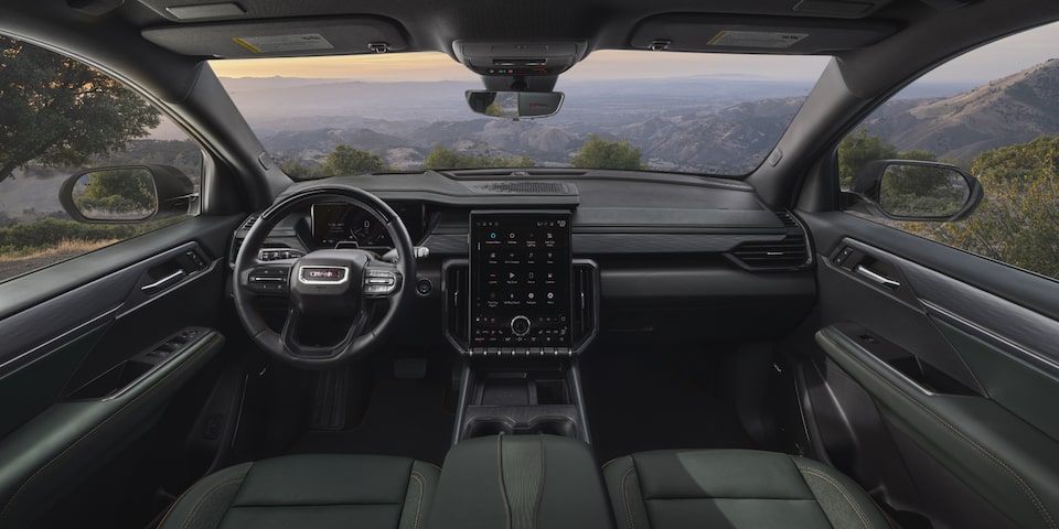 Interiors of the 2025 GMC Acadia AT4 with its sunroof open.