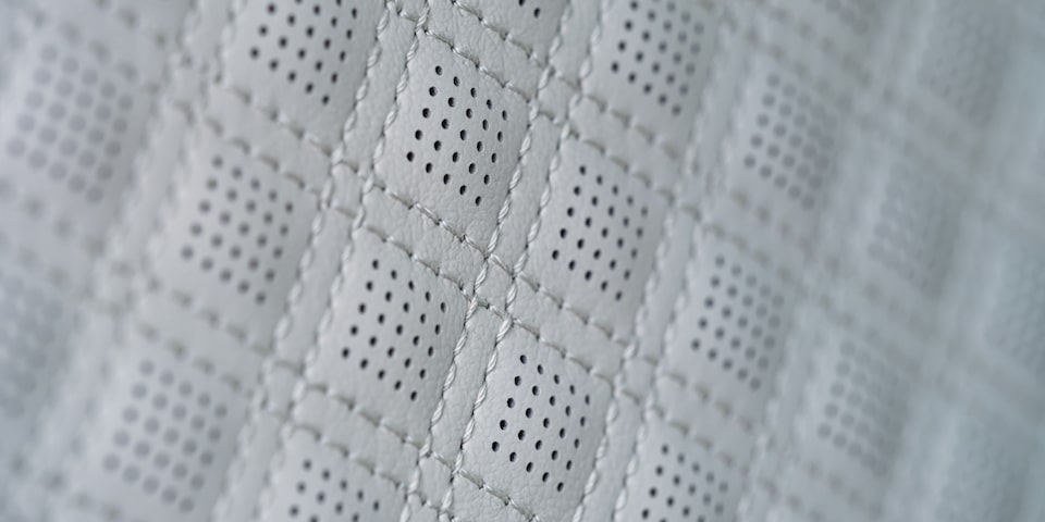 Close up view of the leather stitching on a seat of the 2025 GMC Acadia Denali.