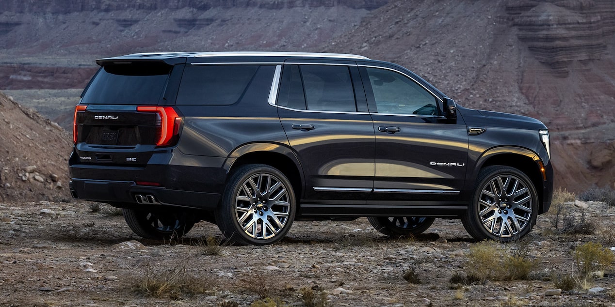 Side View of the 2025 GMC Yukon SUV parked alone in a rough terrain.