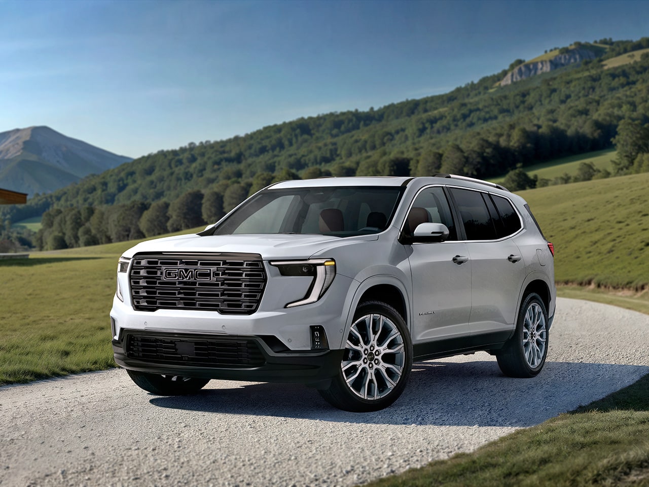 Vue latérale avant du VUS intermédiaire de luxe GMC Acadia Denali 2026 stationné dans une allée.
