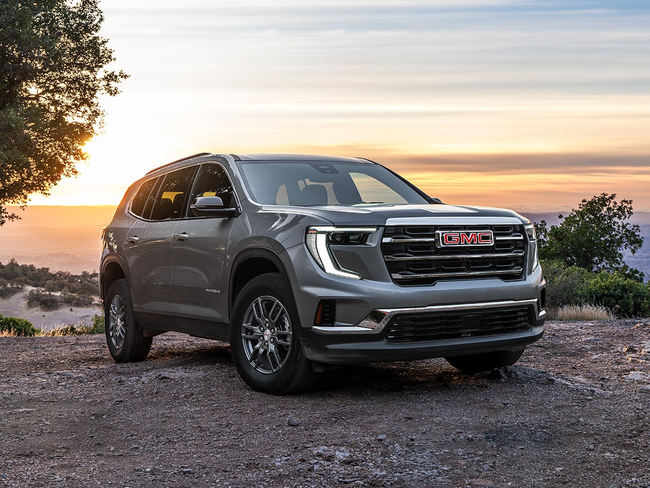 Vue latérale avant du GMC Acadia 2026 stationné près d’une falaise.