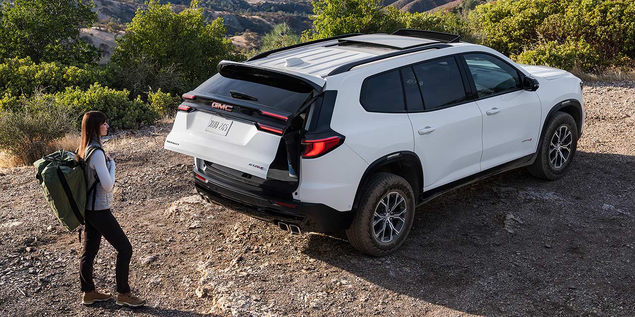 Vue à vol d'oiseau d'une personne utilisant le hayon électrique Autosense du GMC Acadia AT4 2026.