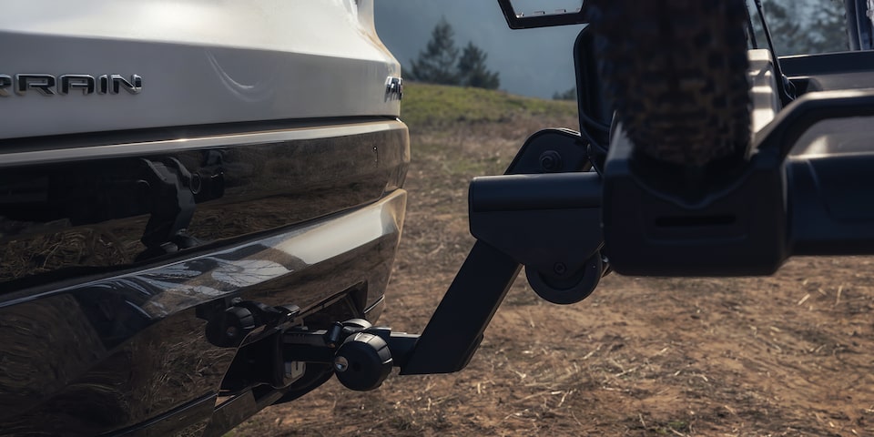 Vue rapprochée de l’attelage du VUS compact hors route GMC Terrain AT4 2026 en mouvement dans la forêt.