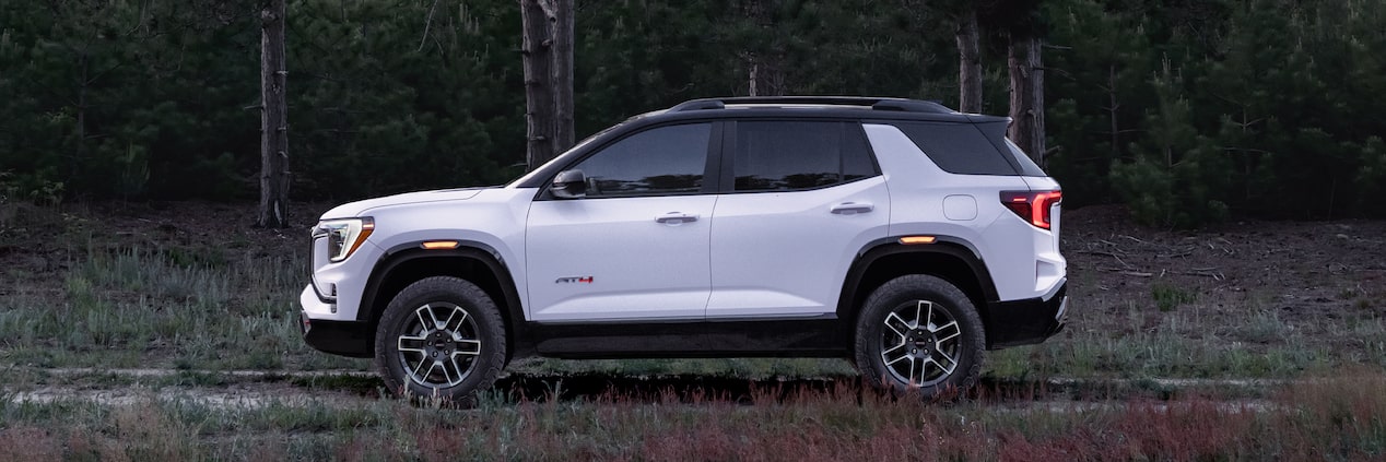 Side View of the 2026 GMC Terrain AT4 Small Off-Road SUV Driving Through the Forest.