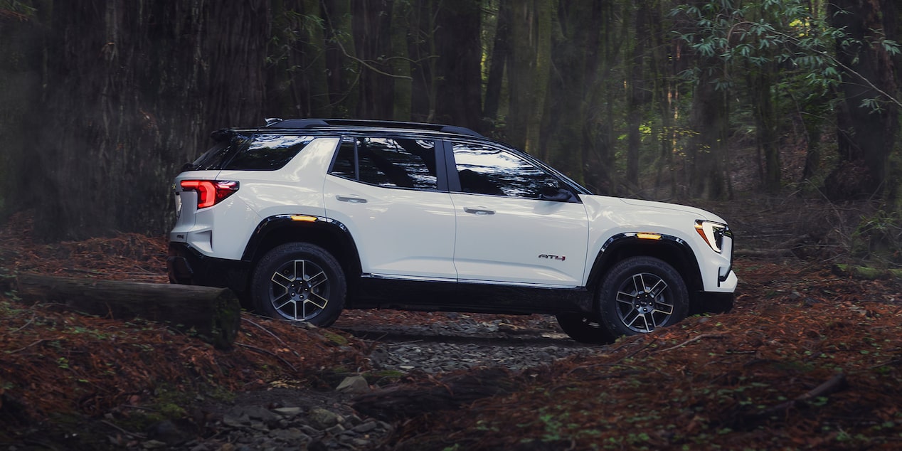 Side view of the 2026 GMC Terrain off-roading in a forest.