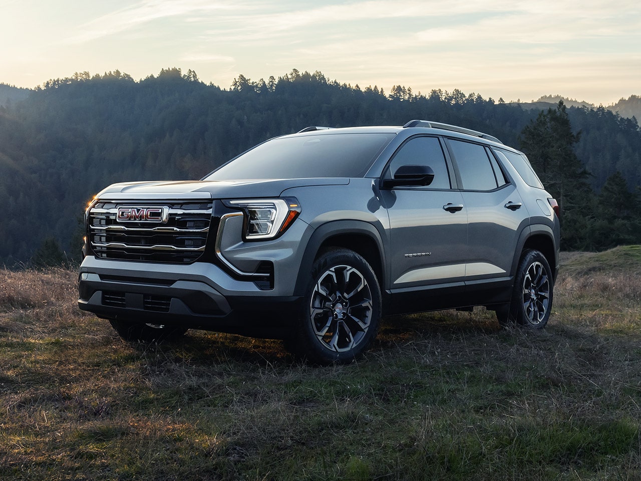 Vue latérale avant du GMC Terrain Élévation 2026 stationné sur une colline à l’aube.