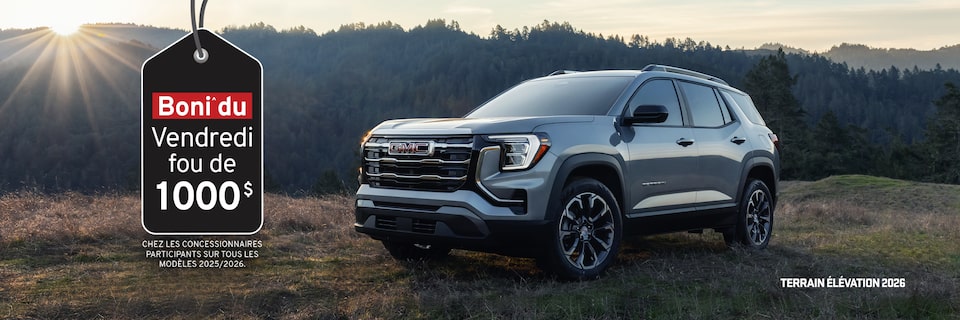Trois véhicules GMC Terrain 2026 stationnés les uns à côté des autres au pied d’une montagne.