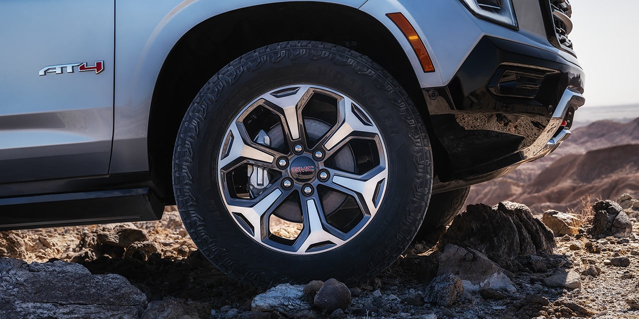  Vue rapprochée des pneus tout-terrain audacieux du VUS tout-terrain pleine grandeur GMC Yukon AT4 2026.