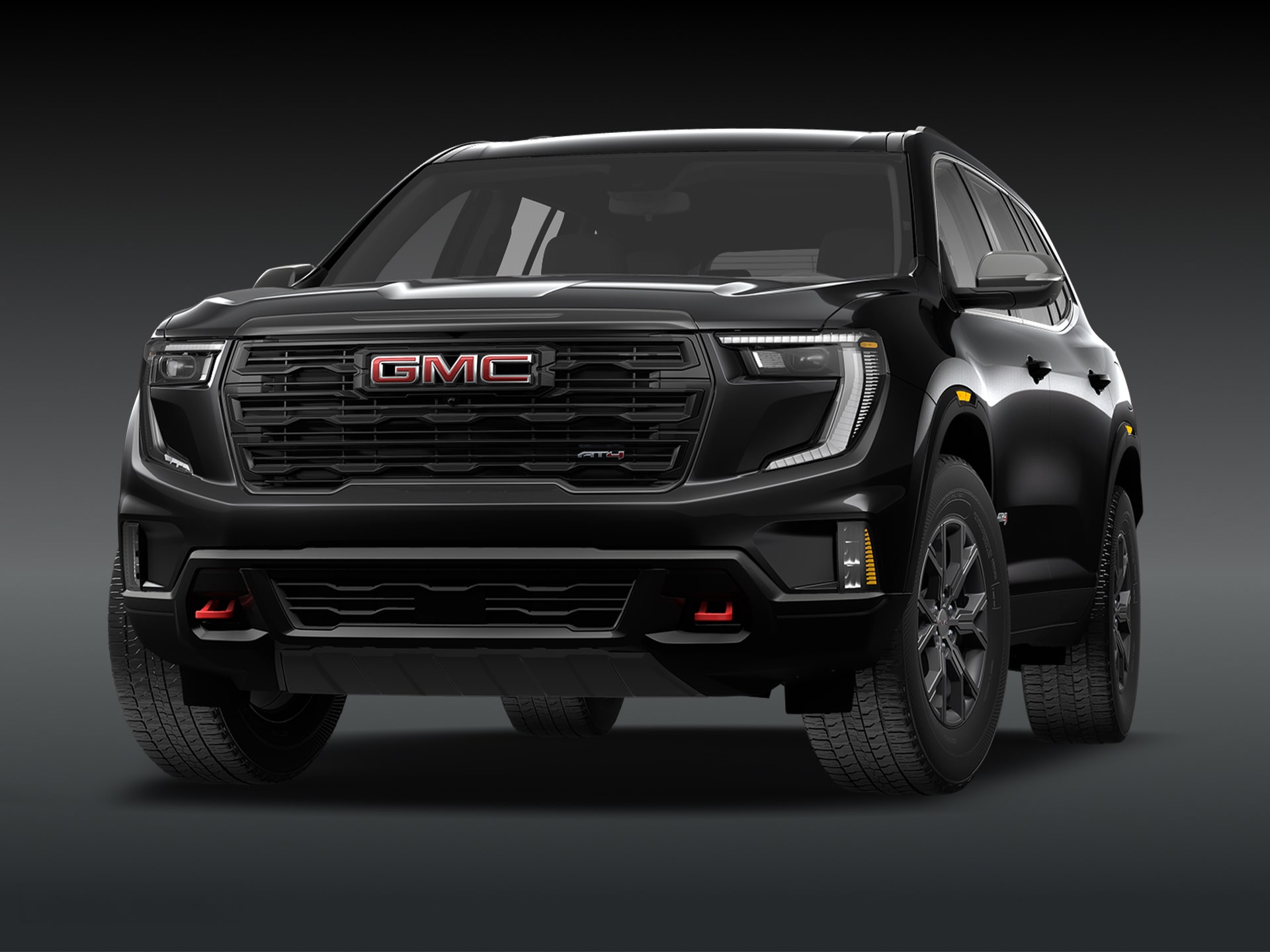 Vue de trois quarts avant du SUV GMC Acadia AT4 2027, couleur « Ebony Twilight Metallic », sur fond sombre.