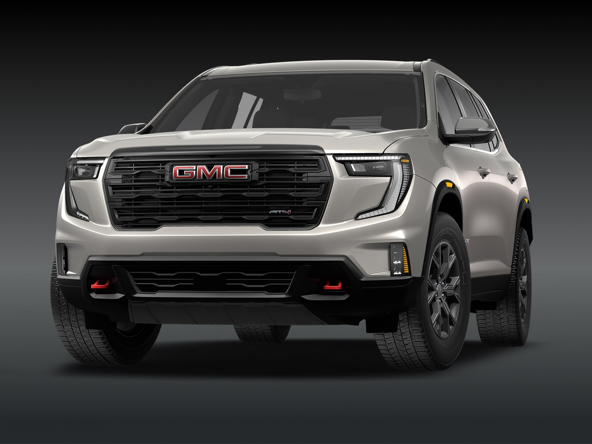 Vue de trois quarts avant du SUV GMC Acadia AT4 2027, couleur « Riverstone Metallic », sur fond sombre.