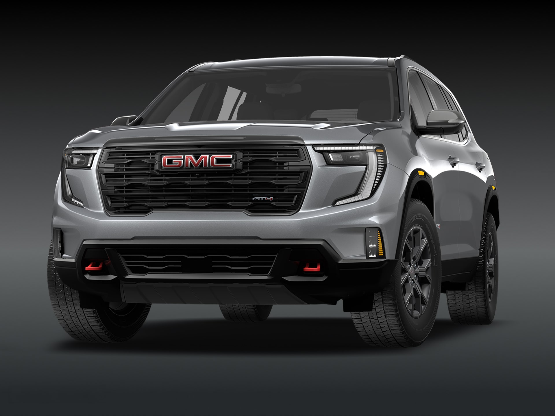 Vue de trois quarts avant du SUV GMC Acadia AT4 2027, couleur « Sterling Metallic », sur fond sombre.