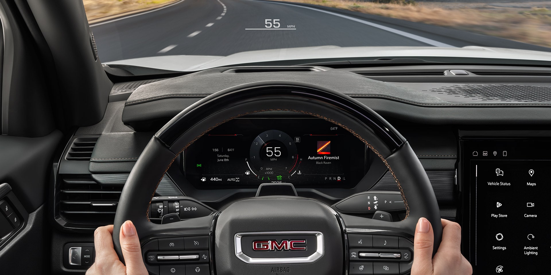 La perspective du conducteur à l’intérieur d’un VUS GMC Acadia 2027, mains sur le volant, montrant le tableau de bord numérique et la route devant vous.