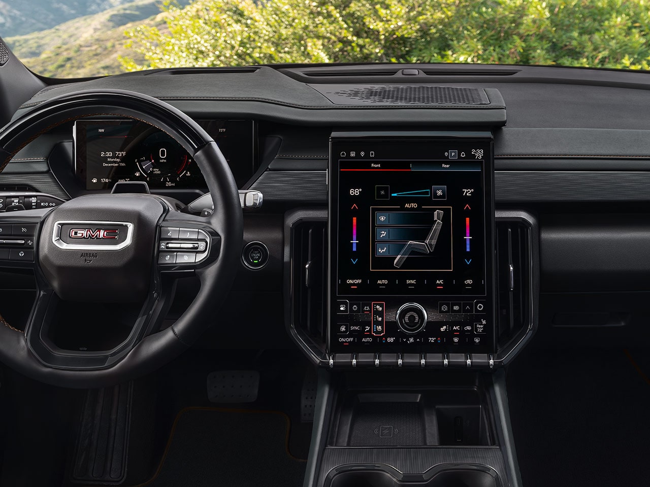 Une vue complète du tableau de bord d’un VUS GMC Acadia 2027 montrant le volant et l’écran d’infodivertissement.