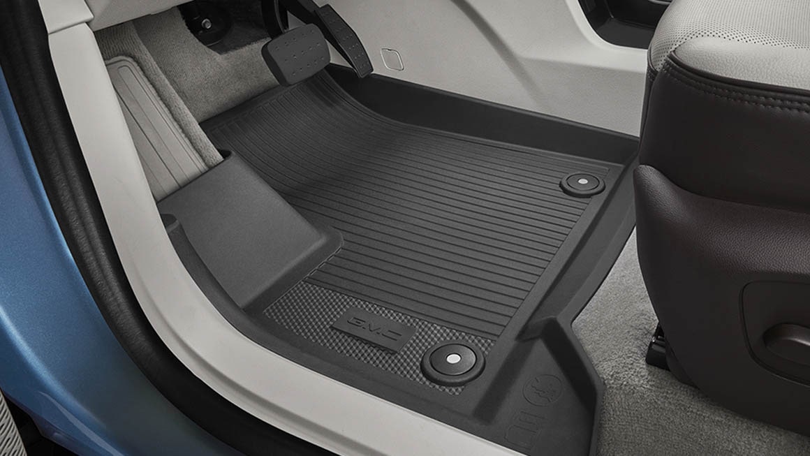 Gros plan sur l'intérieur d'une Acadia Denali de 2027 équipée de tapis de sol noirs.
