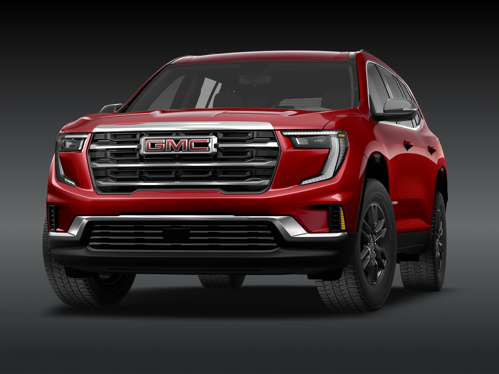 Vue de trois quarts avant du SUV GMC Acadia Elevation 2027 rouge vif sur fond sombre.