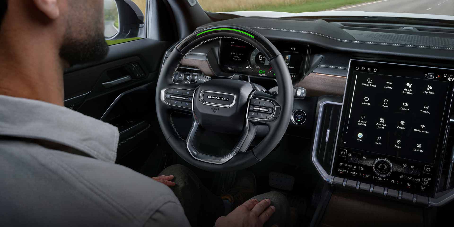 Un homme assis au volant d’un VUS GMC Acadia 2027, les mains sur les genoux, utilisant la fonction Super Cruise.