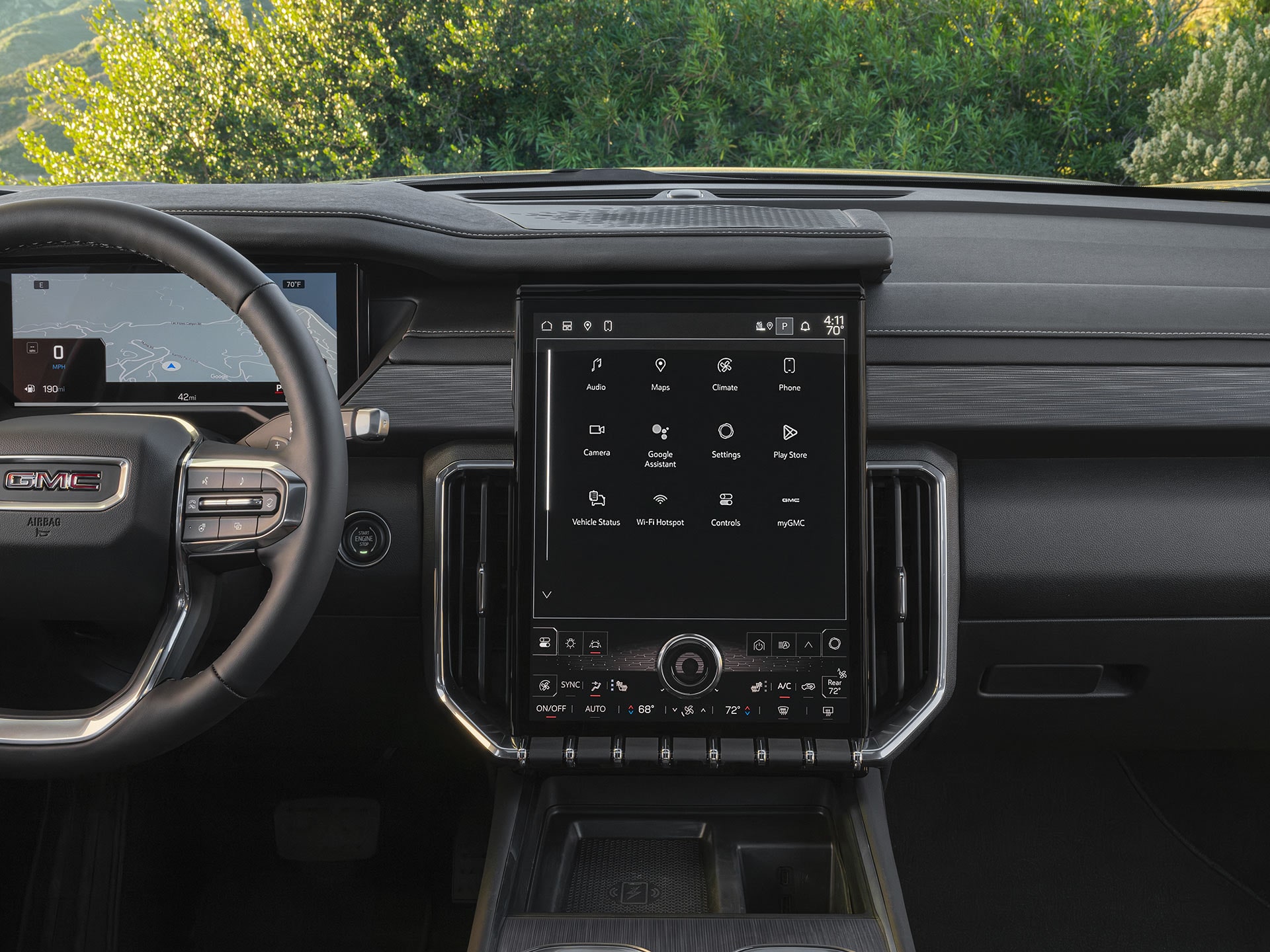 Une photo intérieure large d’un tableau de bord d’un VUS GMC Acadia 2027 avec un écran vertical d’infodivertissement affichant les icônes des applications.