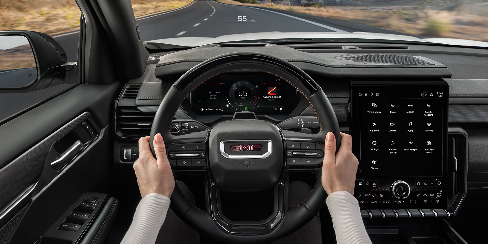 La perspective du conducteur à l’intérieur d’un VUS GMC Acadia 2027, mains sur le volant, montrant le tableau de bord numérique et la route devant vous.