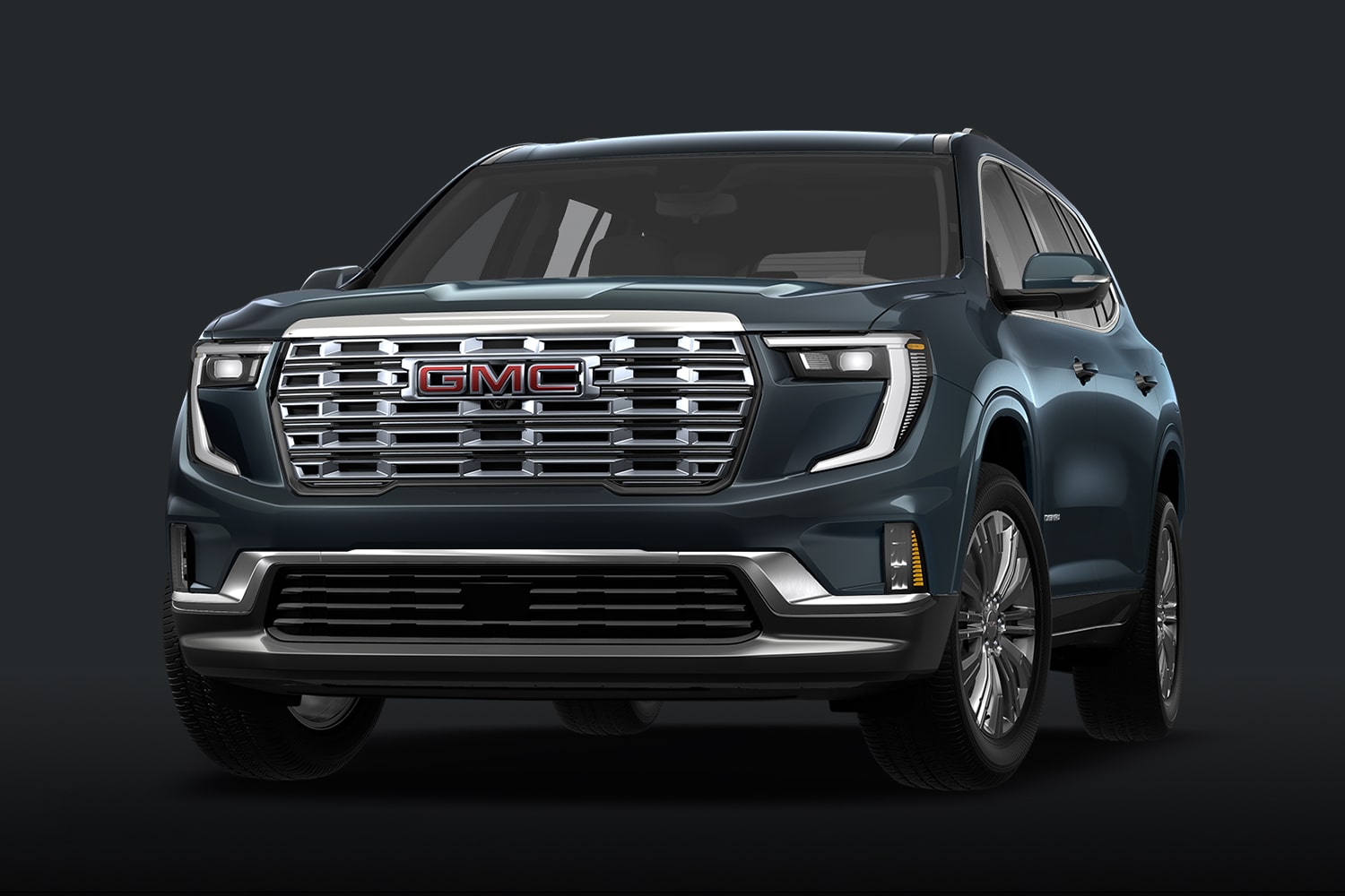 Un SUV GMC Denali bleu sarcelle avec une calandre chromée, sur fond sombre