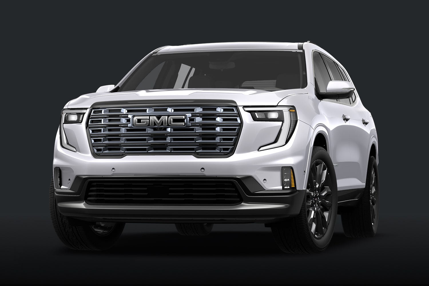Un SUV Denali Ultimate blanc avec une calandre chromée sur fond sombre