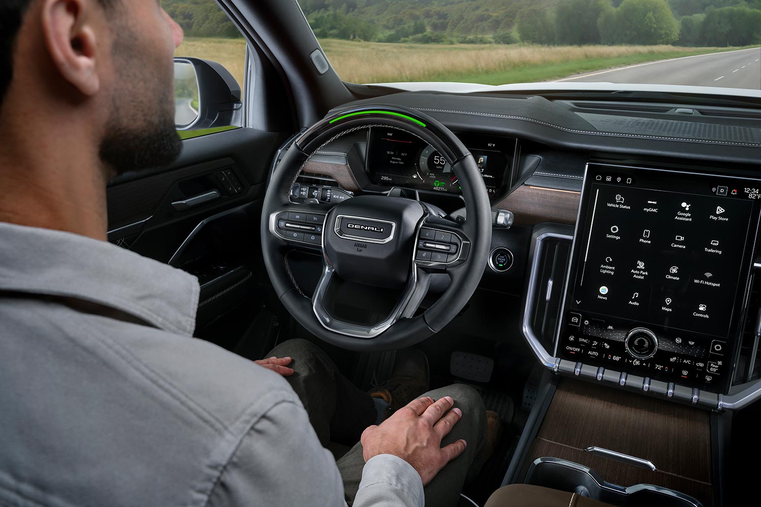 Un homme assis au volant d’un VUS GMC Acadia 2027, les mains sur les genoux, utilisant la fonction Super Cruise.