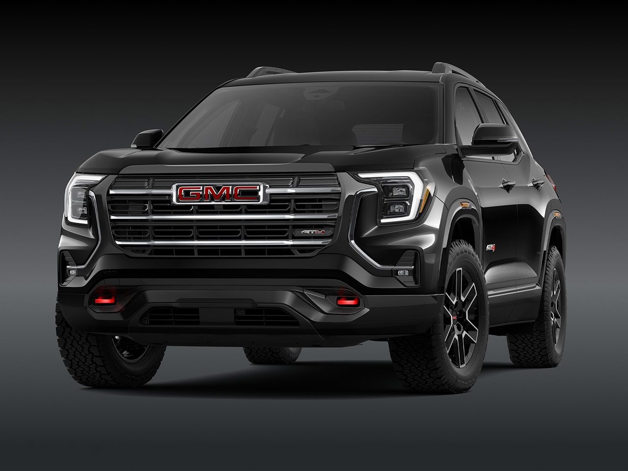 Vue extérieure d’avant d’un SUV AT4 GMC Terrain noir 2027 élégant, avec une calandre proéminente, des phares et des pneus robustes.