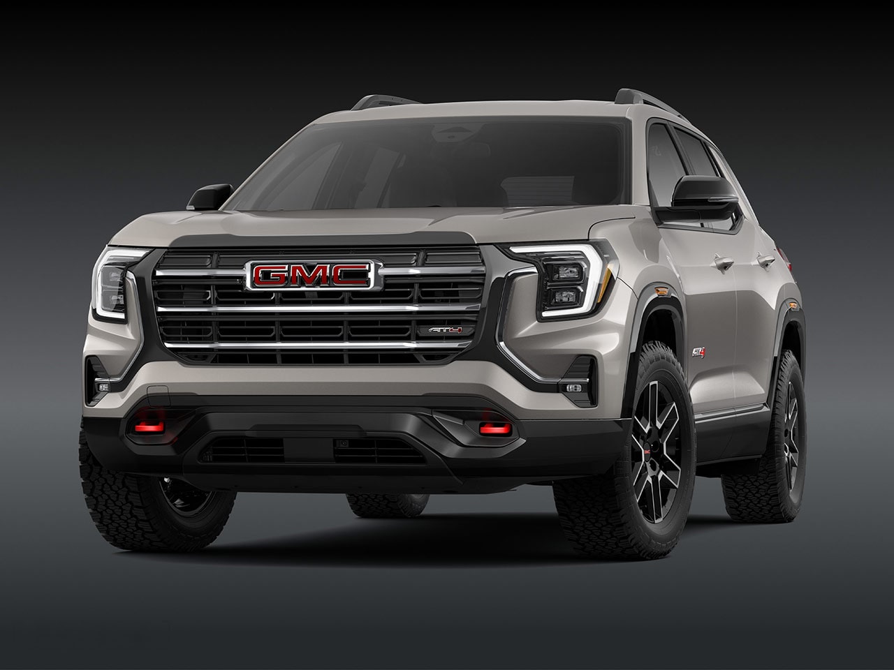 Une vue extérieure frontale d’un SUV GMC Terrain AT4 2027 marron clair avec une calandre proéminente, des phares et des pneus robustes.